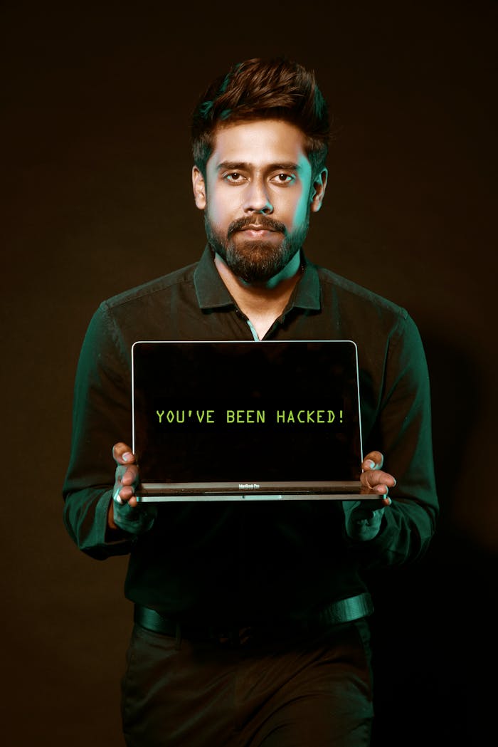 why-choose-us A man showing a laptop with a 'You've been hacked' message, symbolizing cyber security threats.